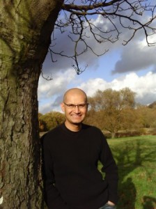 Green Ray Coaching/environment - Joe Britto leaning against a tree